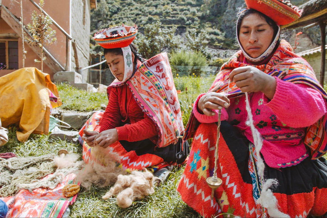 Quechua artisan spinning yarn with a traditional phuska drop spindle