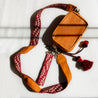 A collection of styled pieces from our Campo que Canta collection, Mini Leather Bag with artisan woven strap and two keychains