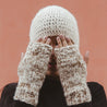 Yura Knit Fingerless Alpaca Gloves Awamaki Peru Sand - lifestyle image of woman covering her eyes wearing a knit hat and gloves